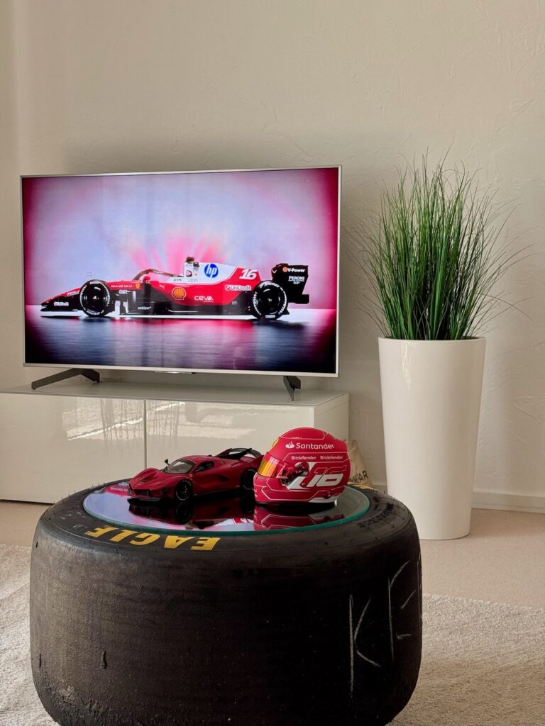 Slick-Tisch im Wohnzimmer, darauf Modellauto und Helm