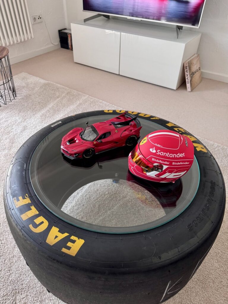 Blick von oben auf die Glasplatte mit Ferrari-Modell und Helm