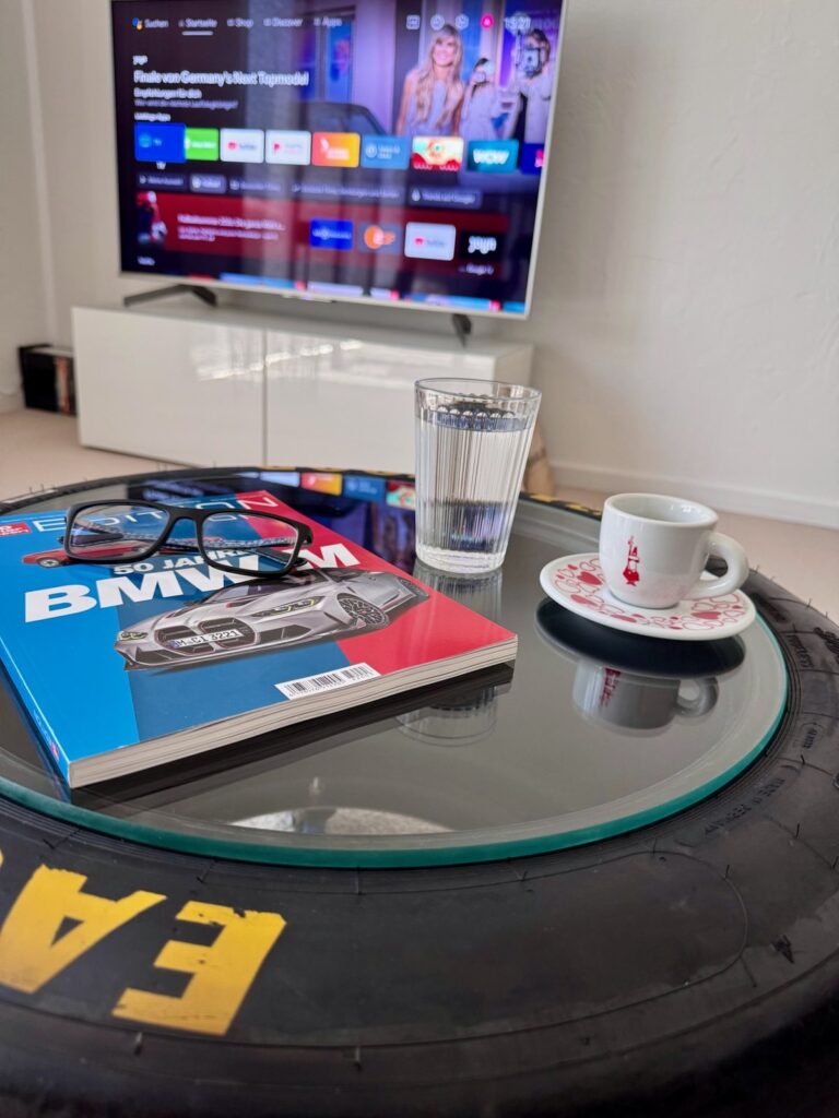 Magazin, Wasserglas und Espressotasse auf dem Slick-Tisch