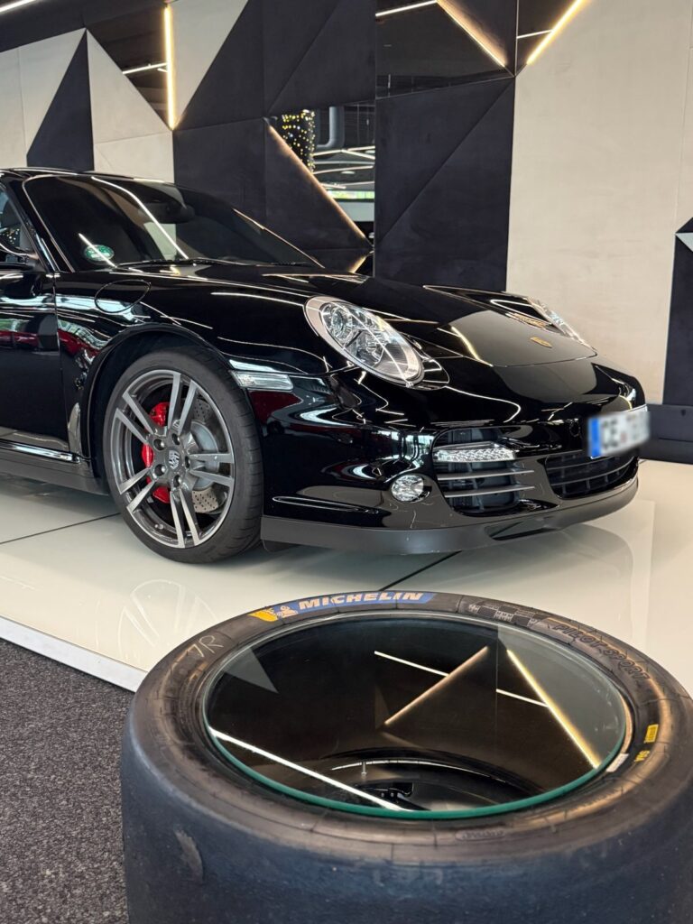 Slick-Tisch vor einem schwarzen Porsche 911