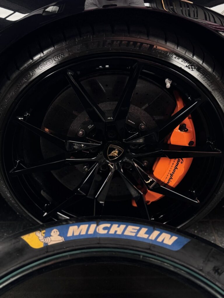 Slick-Tisch vor oranger Bremsanlage eines Lamborghini