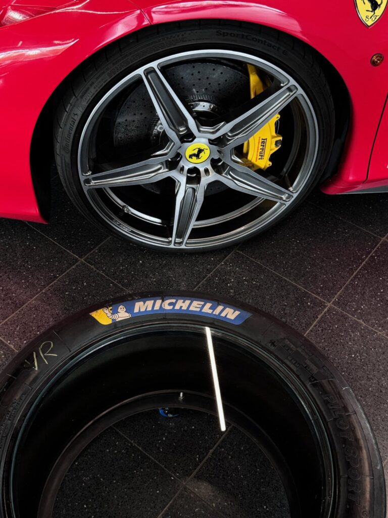 Slick-Tisch vor dem Rad eines Ferrari